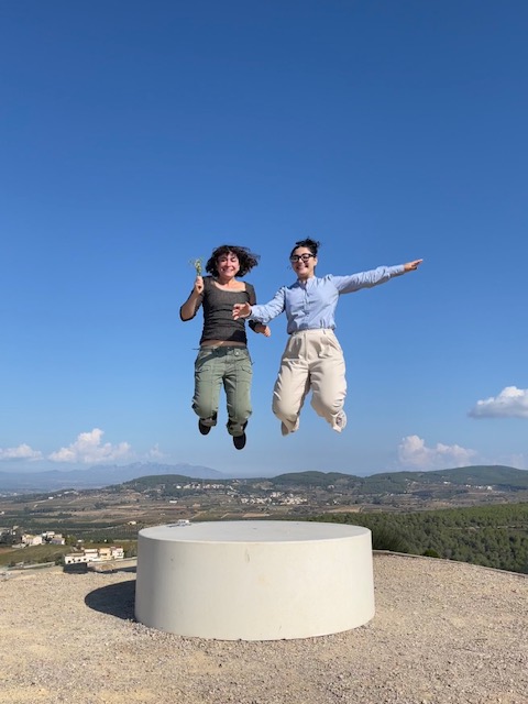 Two guests jumping joyfully on a hilltop terrace overlooking the Penedès valley on a private wine tour with a WSET Level 3 certified Cava expert and private wine guide