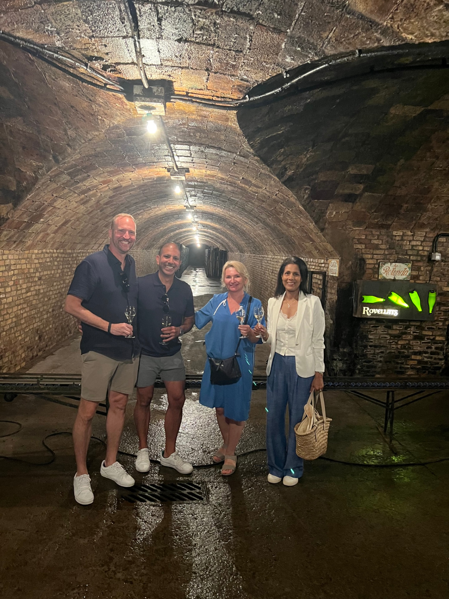 Guests holding Cava glasses in a historic underground brick cellar at a Penedès winery with Alexandra Kalinina, WSET Level 3 certified Cava expert and private wine guide