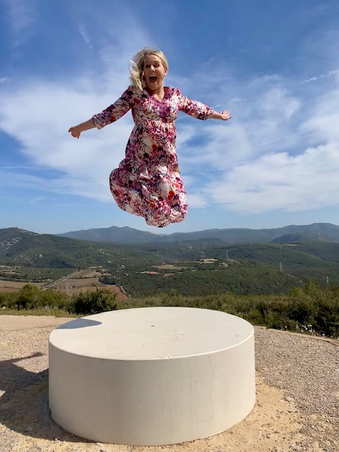 Joyful jump in front of rolling Catalan hills