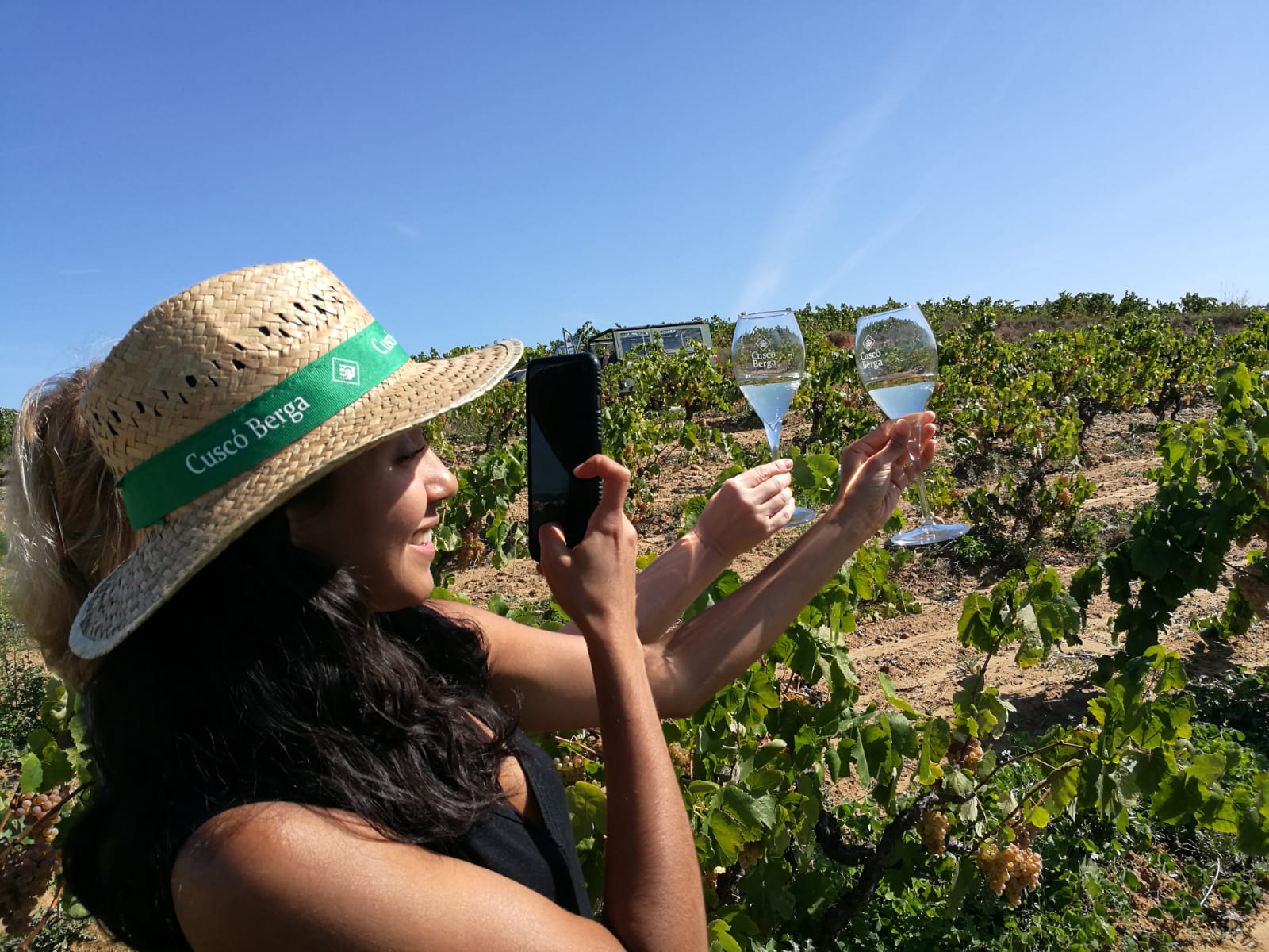Guest photographing two cava glasses in the vineyard